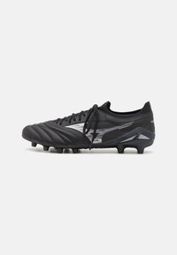 Black soccer cleat with a textured synthetic upper, reflective silver accents, six studs on the sole, and a low-cut design.