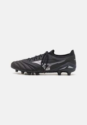 Black soccer cleat with a textured synthetic upper, reflective silver accents, six studs on the sole, and a low-cut design.