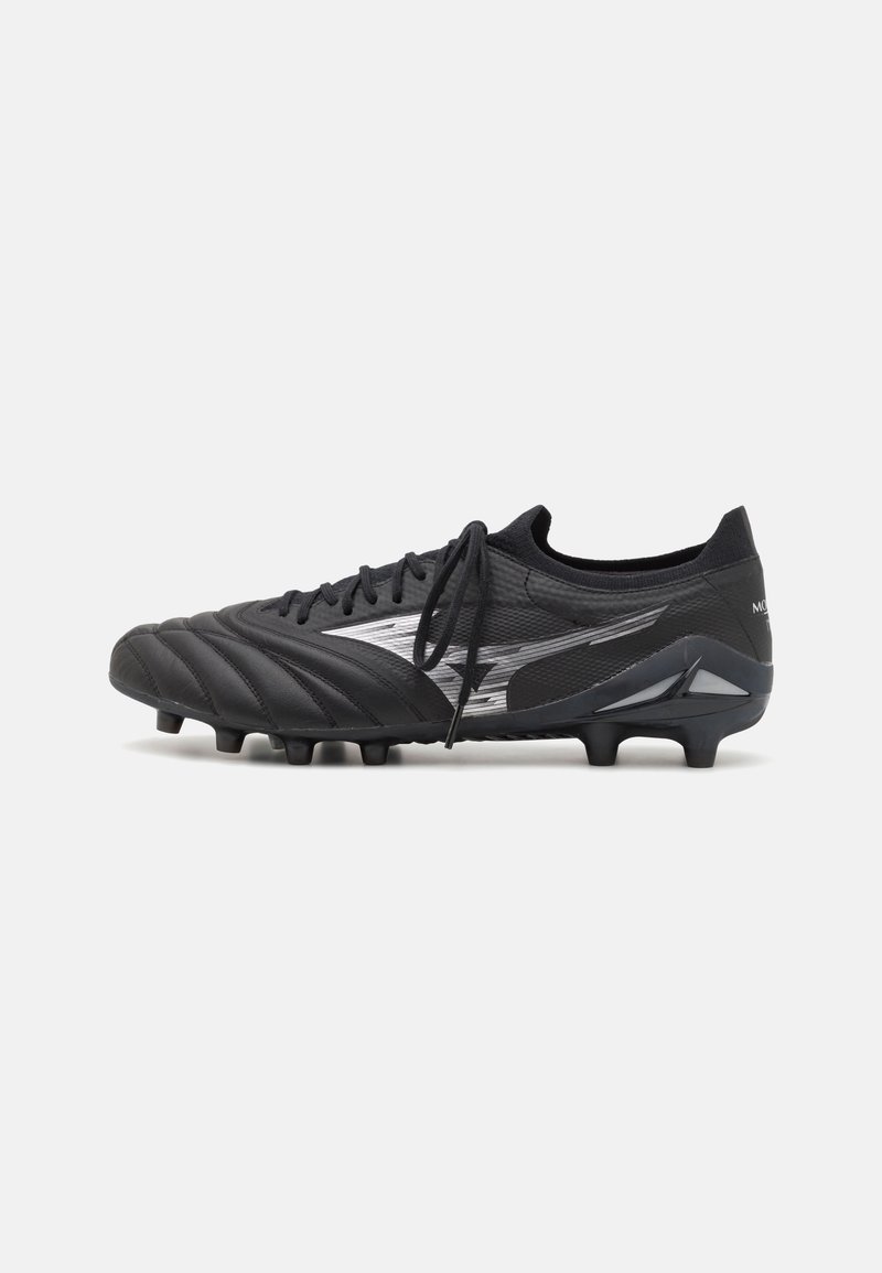 Black soccer cleat with a textured synthetic upper, reflective silver accents, six studs on the sole, and a low-cut design.