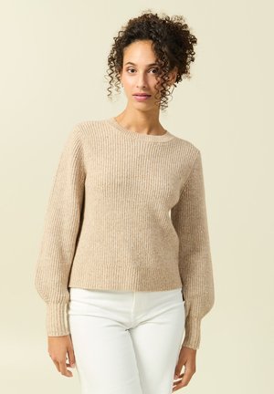 Pull beige côtelé à manches longues et col rond. Fabriqué à partir d'un matériau doux et texturé, il présente un ajustement serré au niveau de l'ourlet et des poignets.