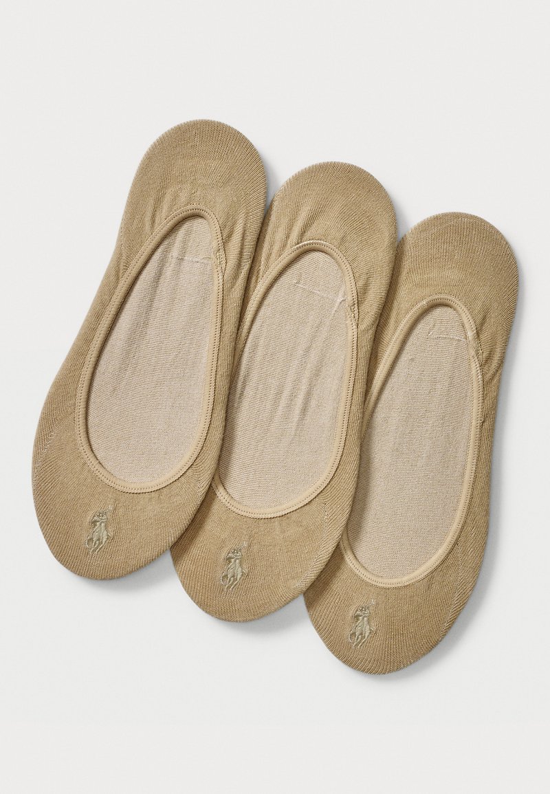 Beige bomullsstumpor med fot och en slät textur samt elastiska kanter. Har en liten logotyp framtill. Tre par ingår.