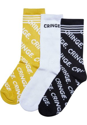 Tre par av bomull crew-sockor i gult, vitt och svart, var och en med texten "CRINGE" i vit fet stil. Randig design på toppen.