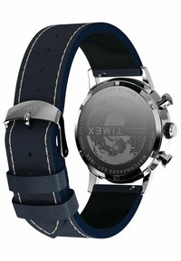 Zegarek Timex z stalową kopertą i granatowym skórzanym paskiem, z białym przeszyciem. Okrąła tarcza z wygrawerowanym wzorem mapy na odwrocie.