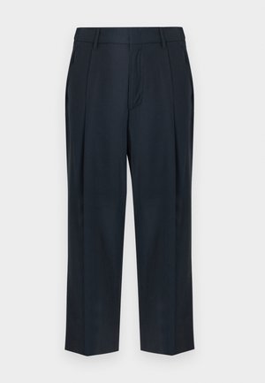 Pantalon bleu marine sur mesure avec passants de ceinture, plis avant, poches latérales et coupe droite sur fond blanc.