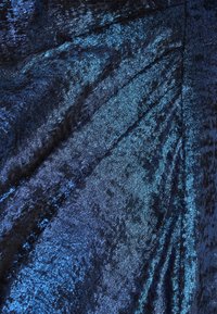 Tekstureret stof i dyb blå med metallisk glans; fremviser et mønster i varierende nuancer og reflekterende kvaliteter med en blød, blød overflade.