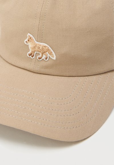 Μπεζ καπέλο μπέιζμπολ με κεντημένο λογότυπο αλεπούς στην μπροστινή πάνελ και εμφανές σχέδιο ραφής στο καμπυλωτό γείσο.