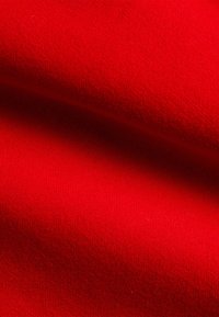 Tessuto rosso con trama testurizzata, che presenta una finitura liscia e una leggera lucentezza. Il colore è vivace, costante e uniforme in tutta la superficie.