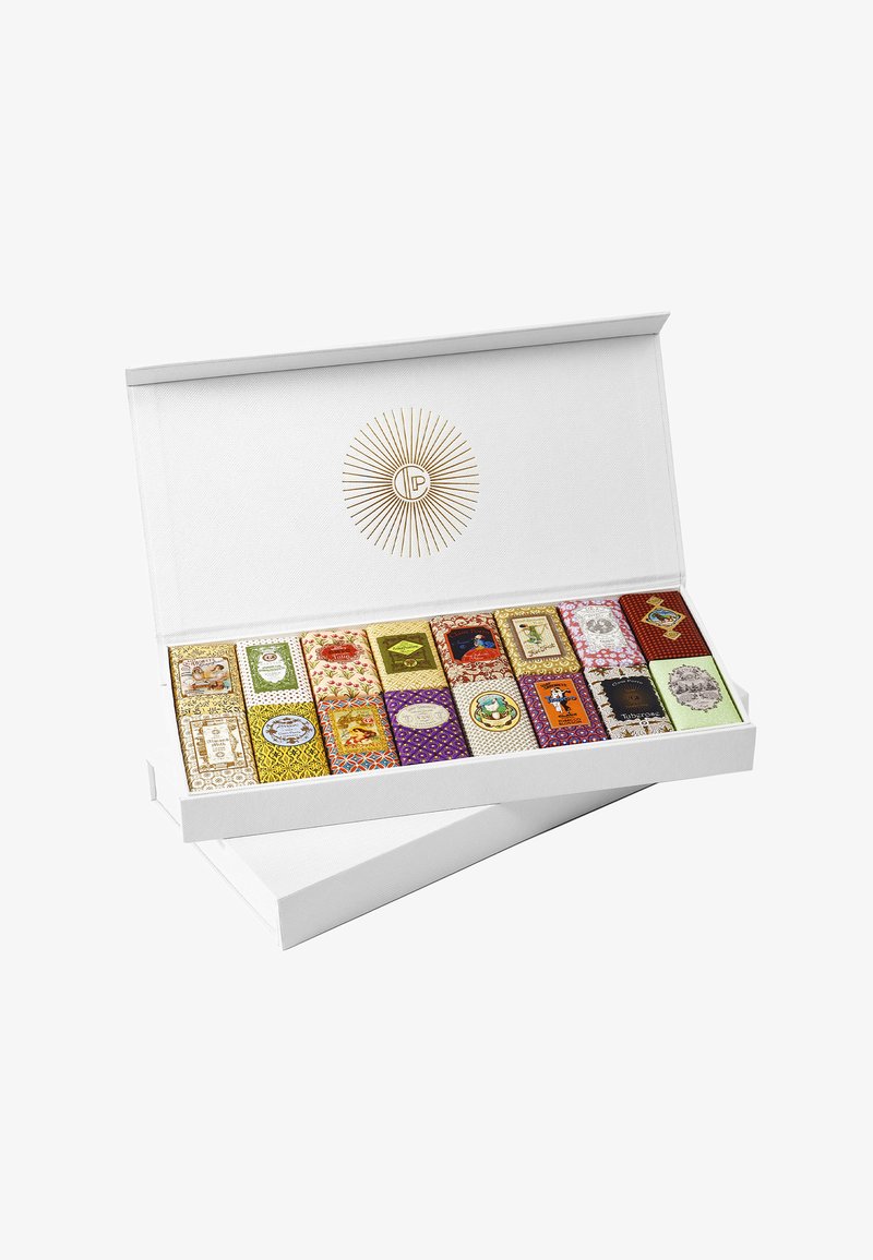 Boîte cadeau avec un extérieur blanc texturé contenant des emballages colorés de chocolats assortis, présentant divers motifs et designs complexes.