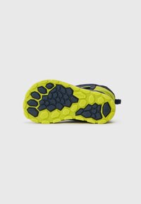 Semelle de chaussure avec une combinaison de couleurs noire et jaune ; présente des motifs de semelle hexagonaux pour l'adhérence et la durabilité ; surface texturée pour la traction.