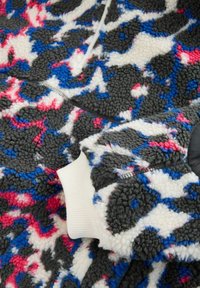 Fleece trui met een meerkleurig patroon in grijs, wit, blauw en roze. Inclusief geribbelde manchetten en een kwart-rits ontwerp.