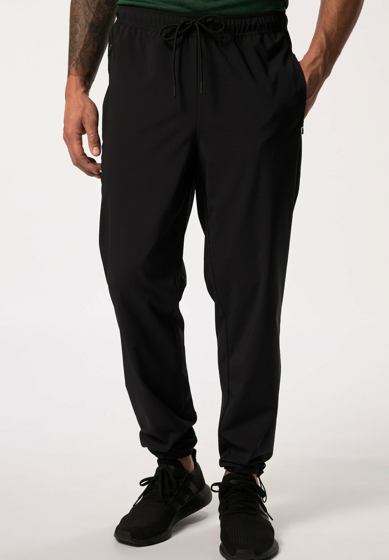 Pantalones deportivos negros con cintura elástica y cordón ajustable; cuentan con bolsillos laterales y un ajuste entallado. Están hechos de una tela ligera.