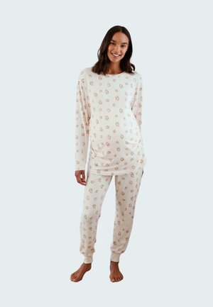 Long-sleeve pajama set in cream with a strawberry print. Soft fabric with elastic cuffs, featuring a relaxed-fit top and pants.