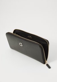 Portefeuille noir zippé en cuir texturé. Présente un logo argenté à l'avant et des accessoires dorés le long de la fermeture éclair. L'intérieur est visible.