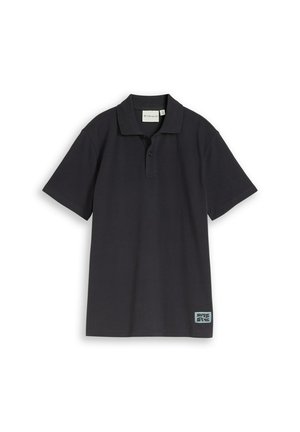 Polo noir à manches courtes avec patte de boutonnage à deux boutons et petite étiquette rectangulaire près de l'ourlet sur fond blanc.