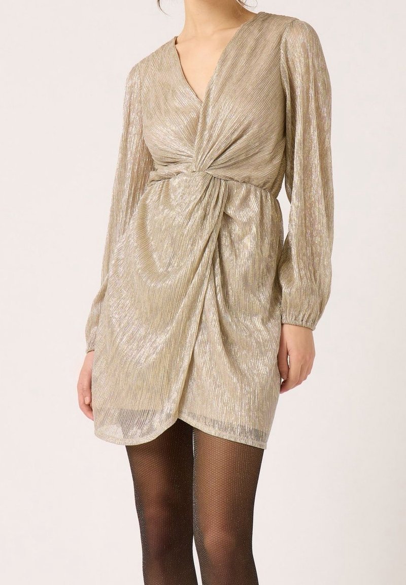 Metalen gouden jurk met een V-hals, lange ballonmouwen en een geknoopte taille. Heeft een gestructureerd, geplooid design en een iets gedrapeerd silhouet.