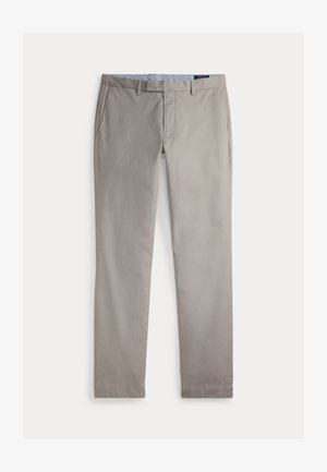 Jasnobeżowe spodnie o prostych nogawkach z szlufkami na pasek, przednimi kieszeniami i zamkiem błyskawicznym.