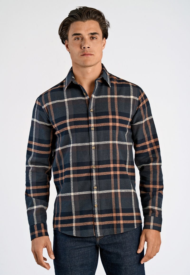 Mörkblå rutig skjorta med långa ärmar som har mönster i brunt och vitt, knappad krage och bröstficka, tillverkad av vävt tyg.