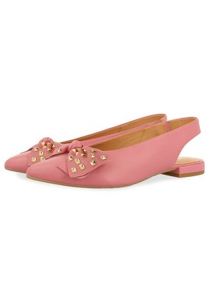 Bailarinas rosas con tiras al tobillo y puntera afilada, decoradas con un lazo anudado que presenta tachuelas doradas en cada zapato.
