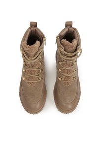 Botine din suede maro cu căptușeală din blană sintetică, accesorii aurii și design cu șireturi. Au o talpă din cauciuc texturat și o bandă de tragere pe spate.