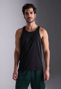 Top desportivo preto sem mangas, feito de um tecido leve, com um decote redondo e uma marcação minimalista no peito.