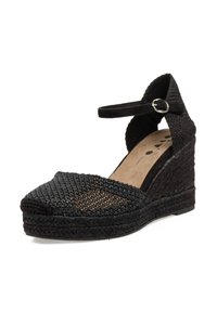 Espadrille de cuña trenzada negra con una correa en el tobillo, que presenta una parte superior texturizada y una base plana y suave en contraste para mayor estabilidad.
