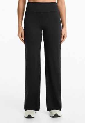 Pantaloni neri a gamba larga realizzati in tessuto elastico con una vita alta, caratterizzati da una texture liscia e senza motivi o decorazioni visibili.