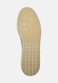 Suola in gomma per sneaker con un motivo testurizzato crema, caratterizzata da design circolari e a onda per la trazione. Il bordo è di un verde menta chiaro.