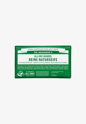 Dr. Bronner's All-One Mandelseife, eingewickelt in grünes Papier mit weißem Text, hat eine rechteckige Form und eine gedruckte Zutatenliste.