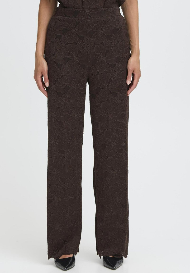 Rudos gėlėmis raštuoti plačiakojai džinsai su tekstūriniu paviršiumi ir plokščiu juosmeniu, su nerištais kraštais ir modelio rankomis šonuose.