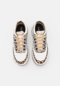 Sneakers bianchi con motivi a zebra e leopardo, dettagli dorati e lacci beige. Presentano una suola imbottita e pannelli laterali testurizzati.