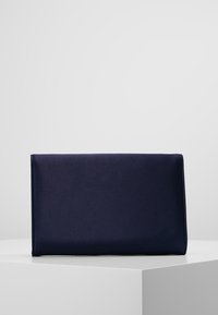 Pochette bleu marine en tissu lisse, avec une forme rectangulaire et des bords nets. Design minimaliste, sans éléments métalliques visibles ni motifs.