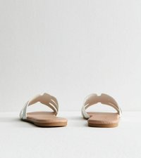 Sandalias planas con parte superior sintética blanca y suela color tostado, con lados abiertos y detalles troquelados, diseñadas para uso casual.