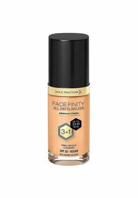 Max Factor Face Finity foundationflaska, cylindrisk form, transparent persikofärgad vätska, svart lock, gyllene etikett, SPF 20, vegansk.