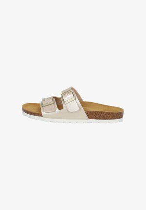 Light beige slide sandals with two adjustable buckles, cork footbed, and white rubber sole. Smooth leather texture with glossy finish.
