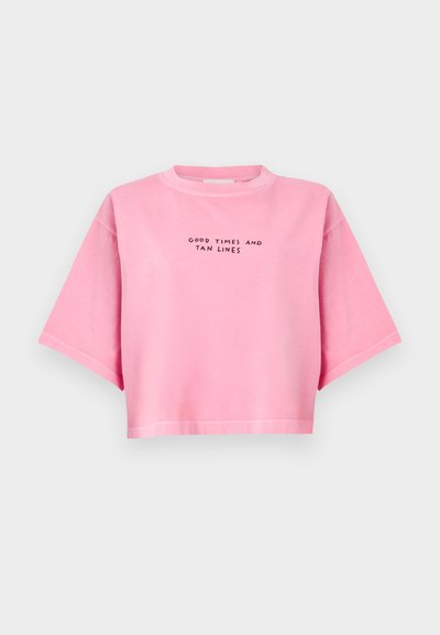 Ροζ κοντομάνικο t-shirt από απαλό ύφασμα, με κοντά μανίκια και το κείμενο "GOOD TIMES AND TAN LINES" τυπωμένο με μαύρα γράμματα.