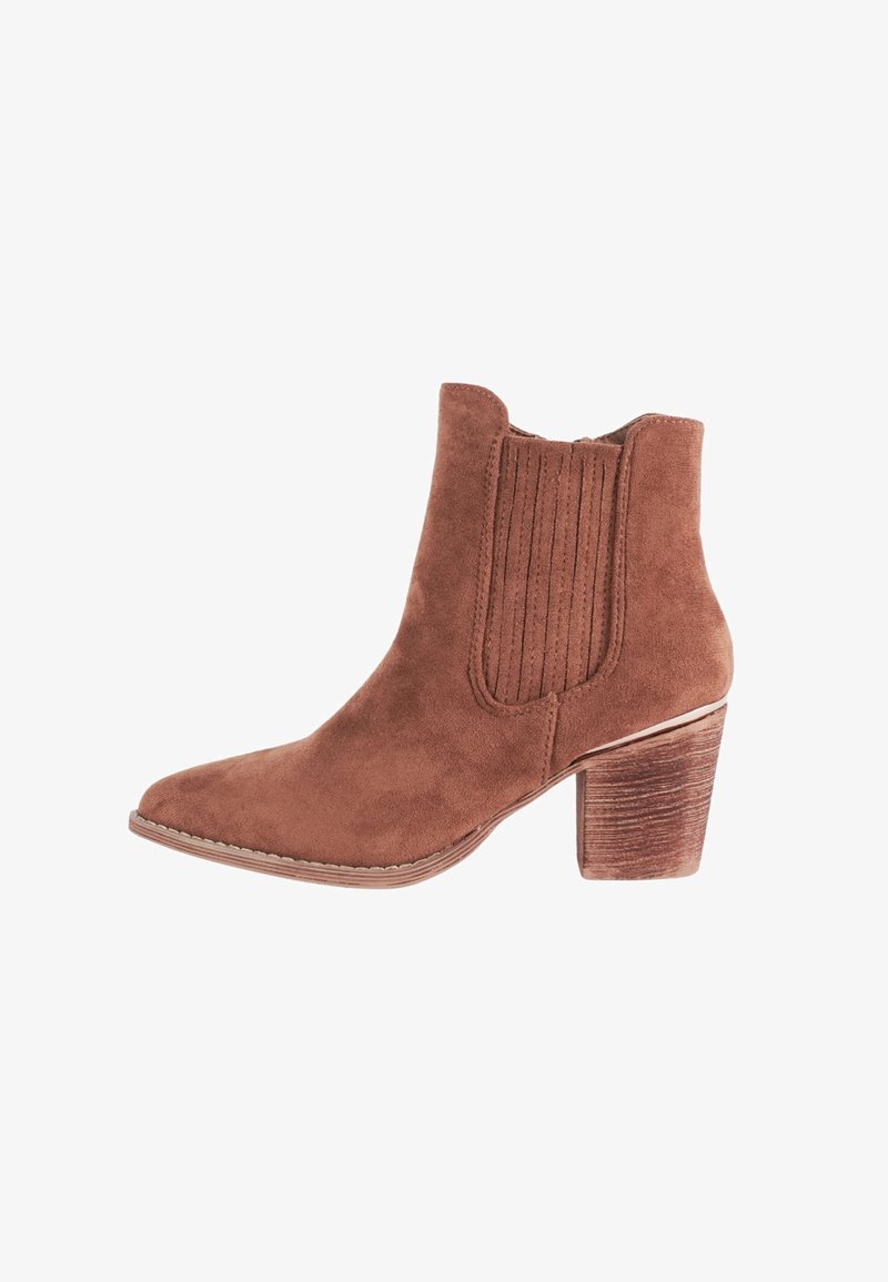 Stivale alla caviglia in suede marrone con punta affilata, pannelli laterali elasticizzati e tacco bloccato strutturato. Presenta dettagli di cucitura discreti lungo la suola.