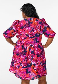 Vestido floral con una mezcla de tonos rosa, rojo y azul marino. Las mangas cortas abullonadas y la cintura fruncida crean una silueta relajada.