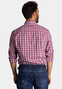 Rood en blauw geblokt overhemd met opgerolde mouwen, met een rugpas en contrasterende stiksels, gecombineerd met marineblauwe denimjeans.
