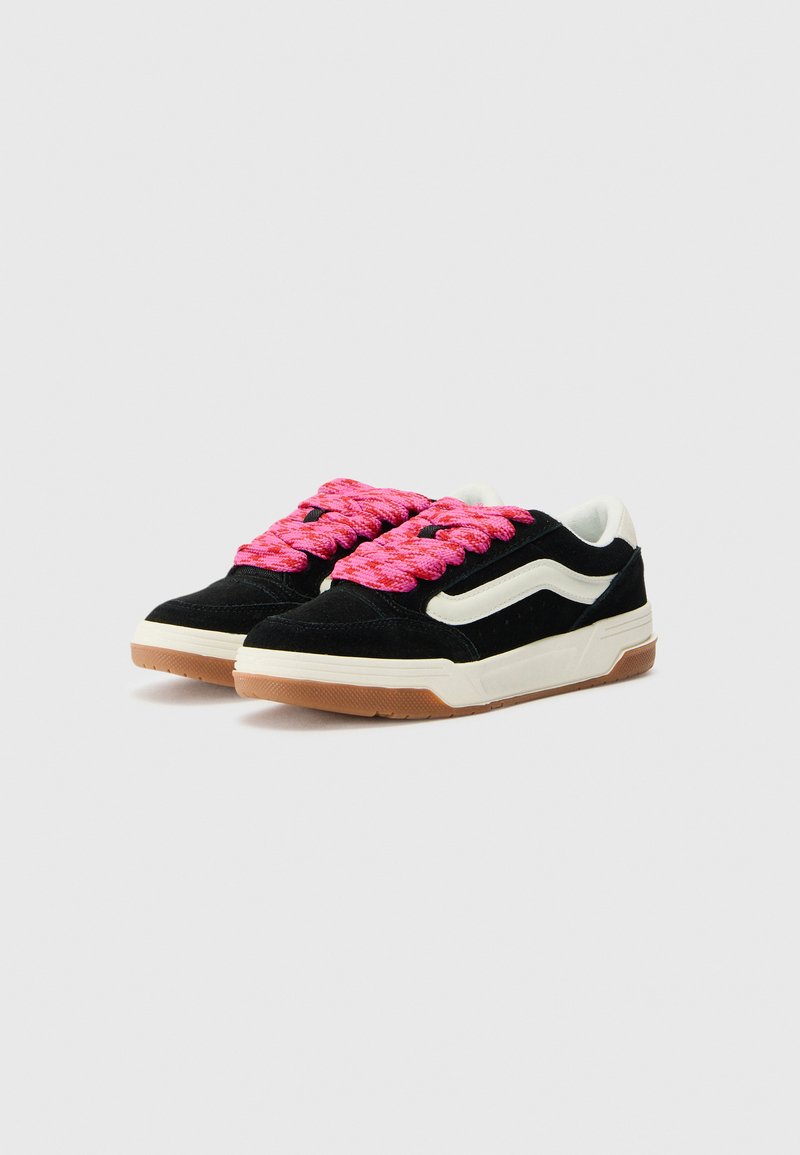 Zapatillas deportivas negras de ante con cordones texturizados rosa, acentos beige y una franja lateral blanca. Presentan una suela de goma y un collar acolchado.