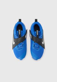 Chaussures de sport bleues avec une tige en mesh, une sangle noire et des accents blancs. Comprend des superpositions texturées et un col rembourré pour le confort.
