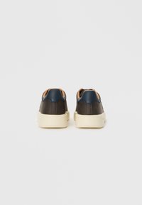 Dark brown leather sneakers with navy accents, cream rubber sole, and flat, round heel. Simple design with minimal stitching details.