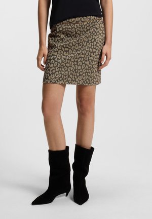 Leopardmønstret miniskørt i en beige og brun farvepalet, med en tætsiddende design og glat tekstur, parret med knæhøje sorte støvler.