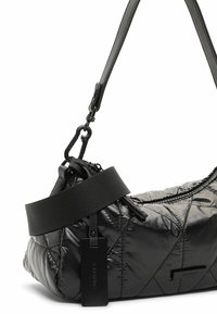 Zwarte gewatteerde schoudertas met een gladde, glanzende textuur, voorzien van een brede zwarte schouderband en een ritssluiting. Inclusief een rechthoekig label.