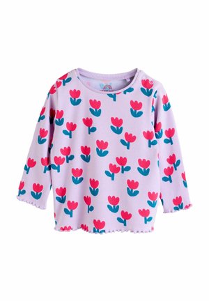 Svetlo vijolična majica z dolgimi rokavi z rebrasto teksturo, s cvetličnim potiskom v roza in modrozeleni barvi. Oblikovanje poudarjajo valovit rob na spodnjem delu in manšetah.