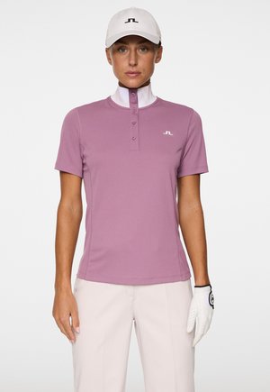 Rosa Golf-Polo mit kurzen Ärmeln, hohem Kragen, einer Knopfleiste mit vier Knöpfen und einem kleinen Logo auf der Brust. Glatte Textur, entworfen für aktiven Einsatz.