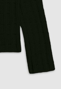 Ciemnozielony dziany sweter z teksturowanym wzorem z wypukłymi sekcjami i luźnym krojem. Widoczne długie rękawy i prążkowane brzegi.