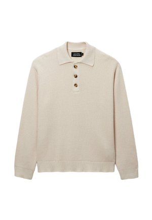 Polo beige à manches longues en maille gaufrée, avec trois boutons marron et un col, des poignets et un ourlet côtelés.