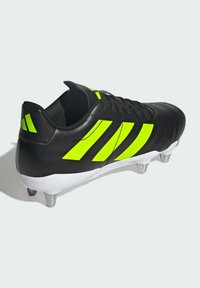Zwarte voetbalschoen met neon groene strepen en accenten. Heeft een leren bovenwerk met textuur, een witte zool en zilveren noppen voor grip.