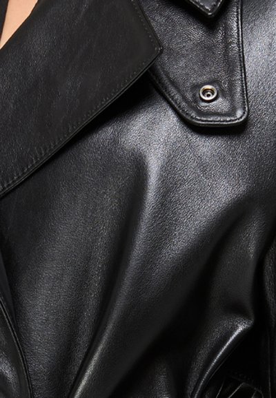 Zwarte leren jas met een grote revers, een gladde textuur en een drukknoopdetail op de kraag. Kenmerkt zich door gestikte accenten voor extra duurzaamheid.