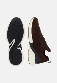 Rudos megztos sportbačiai su stambiu baltu ir juodu padu, su raišteliais ir traukimo juostele, rodomi šoniniuose ir apatinėje pusėje vaizduose ant baltos fono.